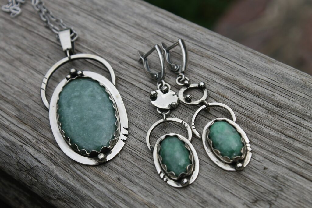 Three pieces of jewelry sitting on top of a wooden table