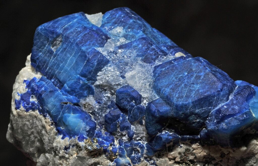 Blue afghanite crystal cluster in rock.